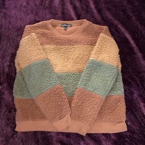 A cream, brown, and army color green sweater.